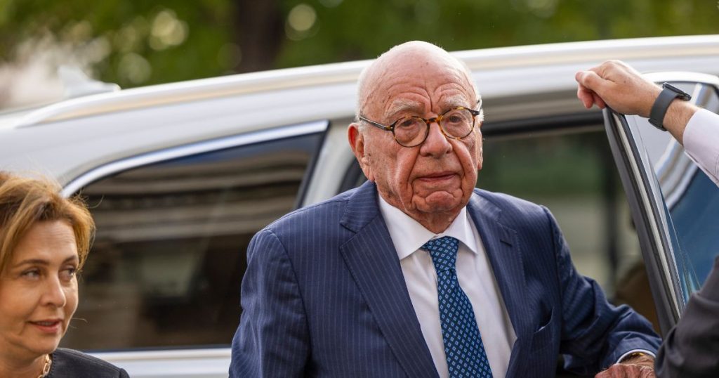 Rupert Murdoch walking toward a Nevada courthouse entrance flanked by legal advisors