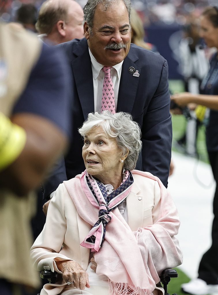 Cal McNair pushes his mother Janice McNair in a wheelchair on the Houston Texans sideline